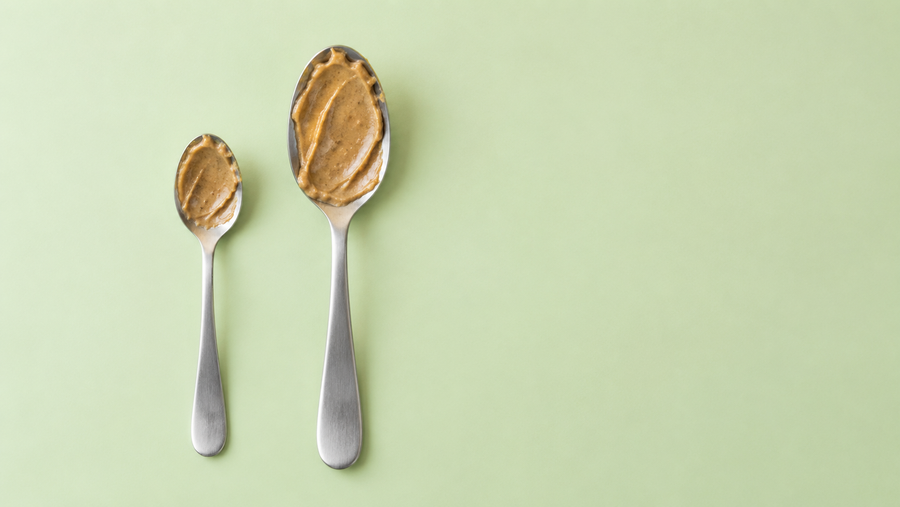 Two differently sized spoons with sunflower seed butter